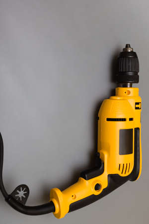 yellow household drill next to which lies a drill. high quality photo