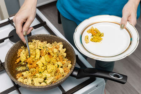 woman pieces of fried chicken putting on a plate. high quality photo