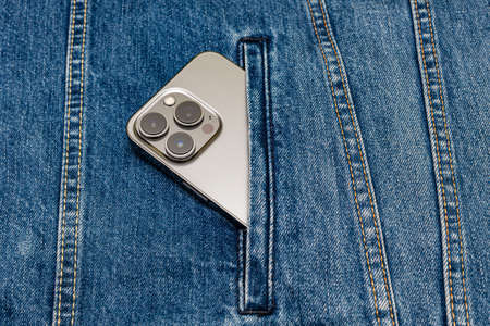 gray smartphone sticking out of the pocket of blue jeans. high quality photoの写真素材