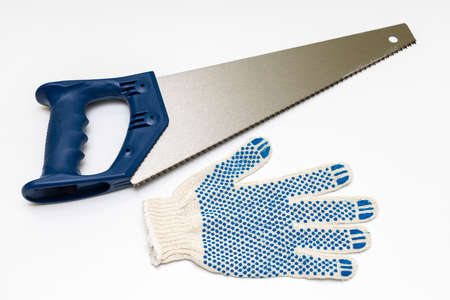 a hand saw for wood next to which lies a work glove. high quality photoの写真素材