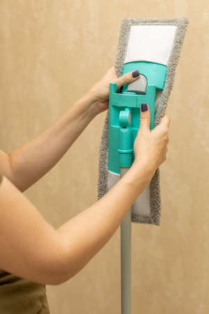 woman putting on a mop head for cleaning. high quality photo