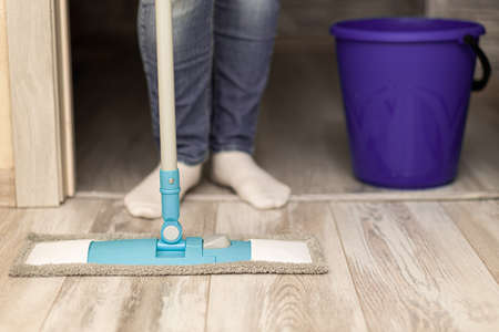a man stands with a mop and a bucket at the door