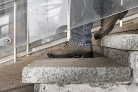 feet in boots go down the stairs. high quality photo