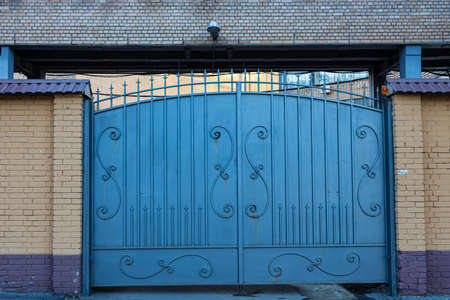 closed large metal gates of blue color. high quality photoの写真素材