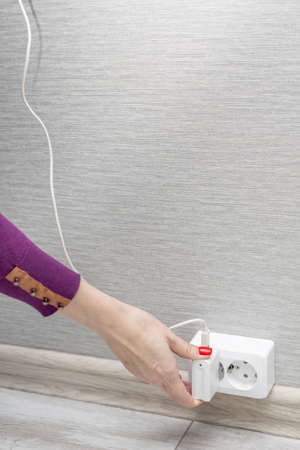 woman's hand inserts charging into the socket. high quality photo