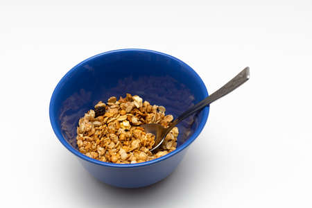 a cup filled with dry breakfast cereal and an iron spoon. high quality photo