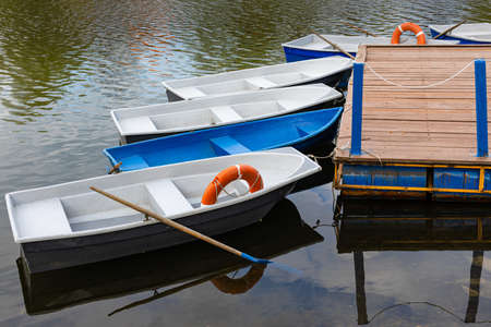a boat with oars stands near a wooden pier. high quality photo