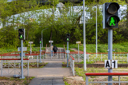 pedestrian crossing over rails with green traffic light. high quality photo