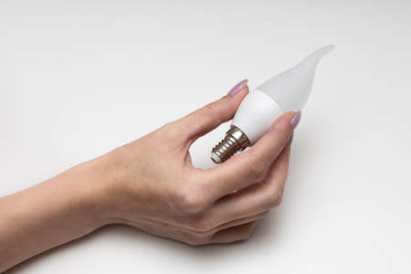 female hand holding an electric lamp in the shape of a candle. high quality photo