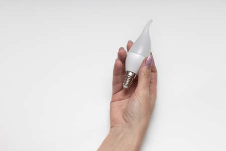female hand holding an electric lamp in the shape of a candle. high quality photo