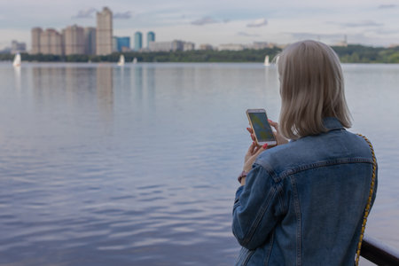 woman looking at the navigator in the phone in nature. high quality photoの写真素材