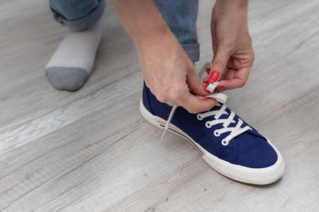 woman tying shoelaces on shod summer shoes. high quality photoの写真素材