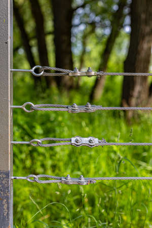 fixing a steel cable on a fence in a park. high quality photo