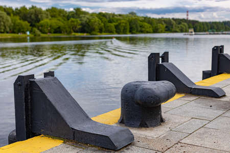 black metal bollard on an empty pier on the river. high quality photo