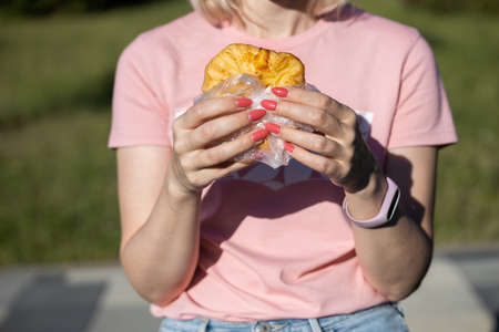 girl holding pastries from dough with both hands being in nature. high quality photoの写真素材
