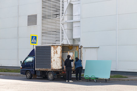 Moscow, Russia - October 14, 2022: worker loading construction material into a van. man loading cargo into the carのeditorial素材