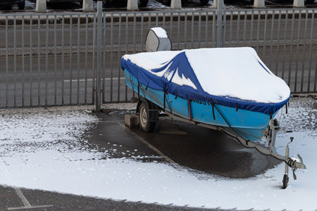 Moscow, Russia - November 16, 2022: boat trailer covered in snow. boat covered in snowのeditorial素材