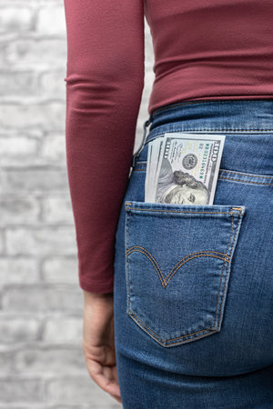 money is in the back pocket of jeans. dollar in pocket. money in a pocketの写真素材