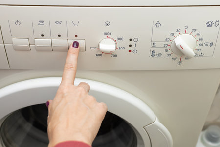 a person chooses a washing mode with a switch. washing mode. temperature mode. washing machine.の写真素材