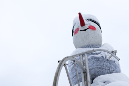 New Year's snowman covered in snow close-up shot. christmas snowman. big Foot. New Year's decoration of the cityの写真素材