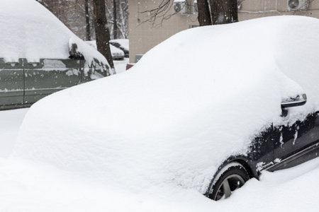 car covered with snow after a snowfall. car covered in snow. car parked in winter.の写真素材