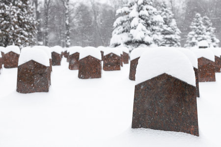tombstone in a cemetery covered with snow in winter. monument in the cemetery. grave in the cemetery in winter.の写真素材