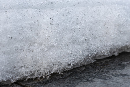 fragment of a layer of snow melting in spring. snowmelt in spring. melting snow
