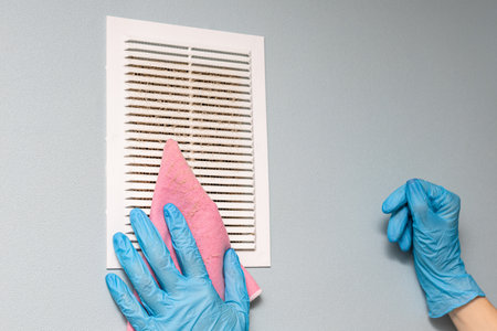 man cleaning the ventilation grill in the room. dirty grill ventilation.