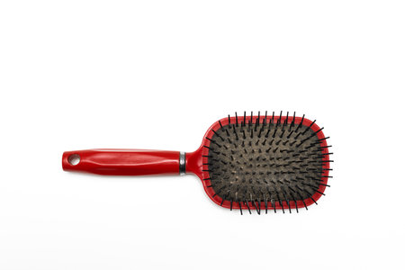 old red hairbrush with sticking out hair. old hairbrush on white background. high quality photo