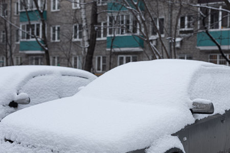 car covered with snow after a snowfall. car after snowfall. snow on the hood of a carの写真素材