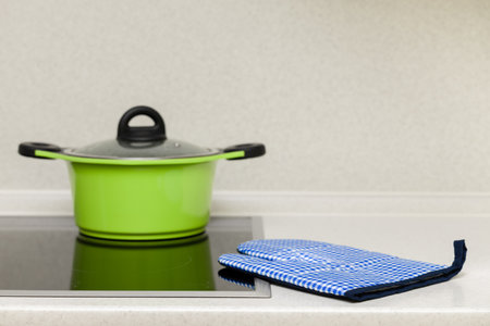 kitchen potholder lies near the hob in the kitchen. oven mitt is in the kitchen. protective gloveの写真素材