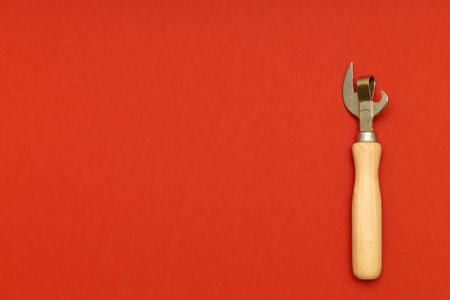 old can opener shot on a red background with a place for an inscription. bottle opener on red backgroundの写真素材