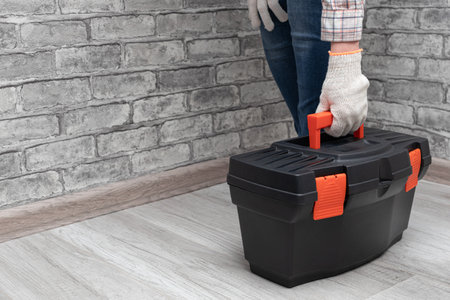 man picks up a box with a working tool. handyman holding tool boxの写真素材