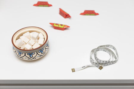 measuring tape lies on the kitchen table near the sweets. getting rid of excess weight. diet and healthy lifestyleの写真素材