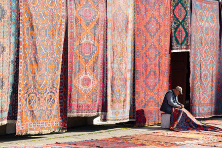 Moscow, Russia - April 22, 2023: oriental street market. man knitting an oriental rugのeditorial素材