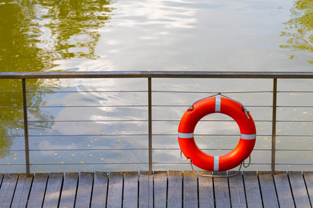 red lifebuoy on the pier without people. marine lifeline. drowning man rescue. red life buy