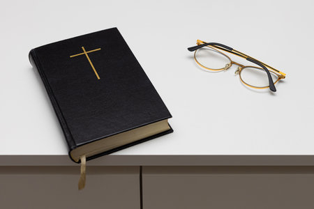 a closed bible with a cross on the cover lies on the table. bible reading