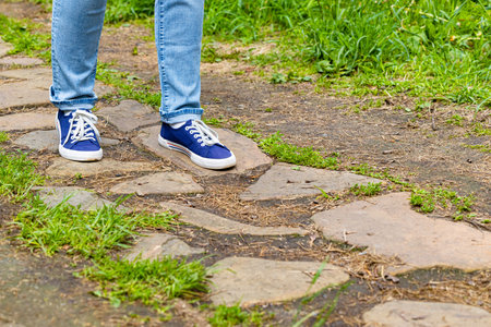 a man walks along a rocky path in the forest. feet walk along the path in the park