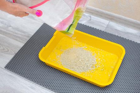 a person pours dry litter from a bag for a cat's litter box. cat litter bag. fresh cat litterの写真素材