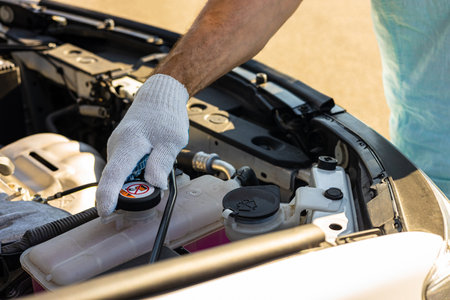 driver check the coolant level in the engine compartment of the car. car coolant expansion tank. master inspects the engine compartment of the car. car engine coolant levelの写真素材