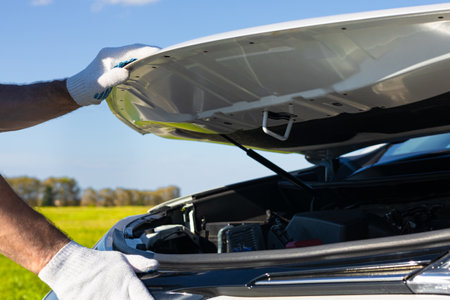 man opens the hood of a car. hand opens car hood lid. High quality photoの写真素材