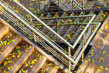 metal railings on the stairs in the park. the high staircase in the park is strewn with leaves. staircase in autumn park. multi-tiered staircase. High quality photoの写真素材
