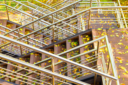 metal railings on the stairs in the park. the high staircase in the park is strewn with leaves....