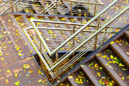 metal railings on the stairs in the park. the high staircase in the park is strewn with leaves. staircase in autumn park. multi-tiered staircase.の写真素材