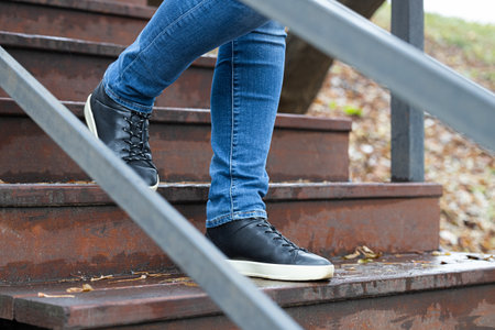 man going down wooden stairs in rainy weather. shoe steps on a wooden step. Stairs wet from rain
