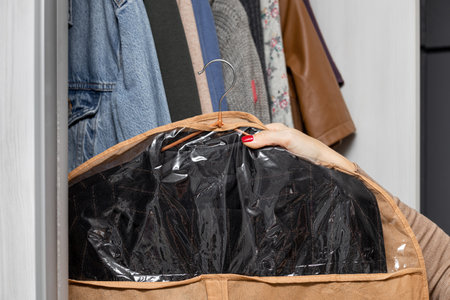 woman hanging clothes storage case in closet. clothes storage case. wardrobe High quality photoの写真素材