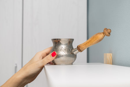 a woman takes a coffee pot from a shelf. old coffee pot. making natural coffee. High quality photoの写真素材