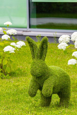 landscape figure of a hare on the lawn in front of the house. topiary figure of a hare