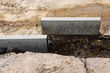 laying curb stones on a sidewalk in the city. curb stone on the road. sidewalk repair. High quality...