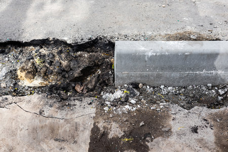 laying curb stones on a sidewalk in the city. curb stone on the road. sidewalk repair. installation of new curbstoneの写真素材